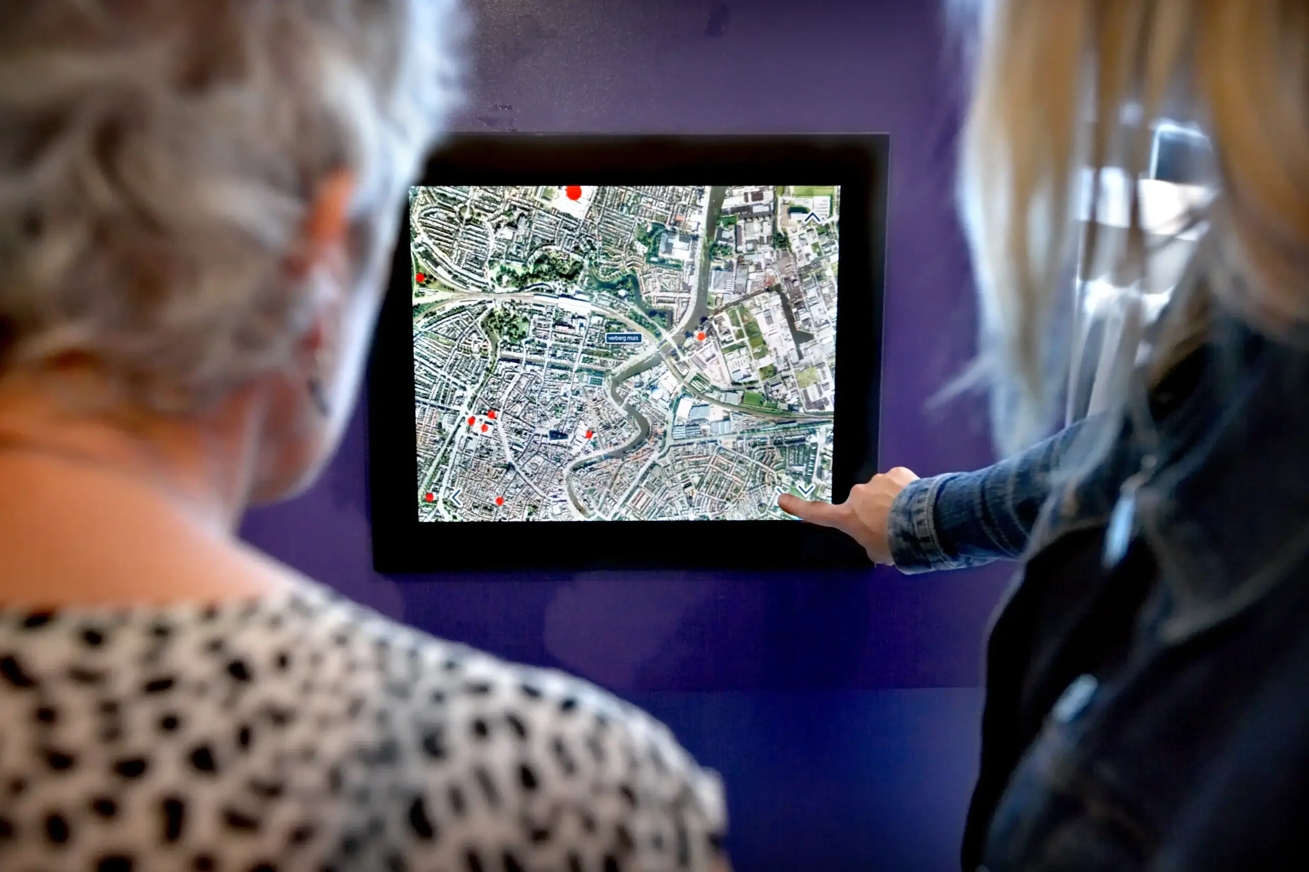 Twee vrouwen gebruiken een digitale kaart in de orientatieruimte van het ABC. 